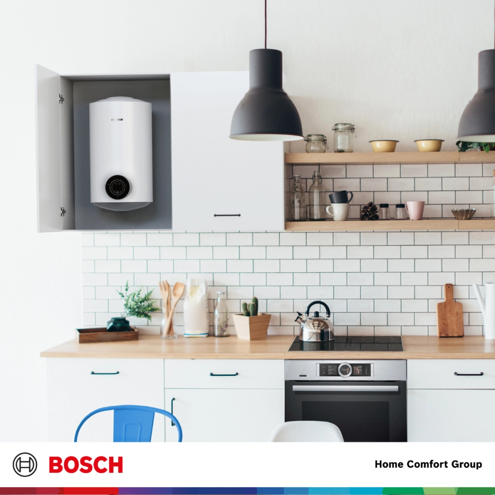 Bright modern kitchen with white cabinets and a wall mounted boiler in an open cabinet Bosch branding visible at bottom edge
